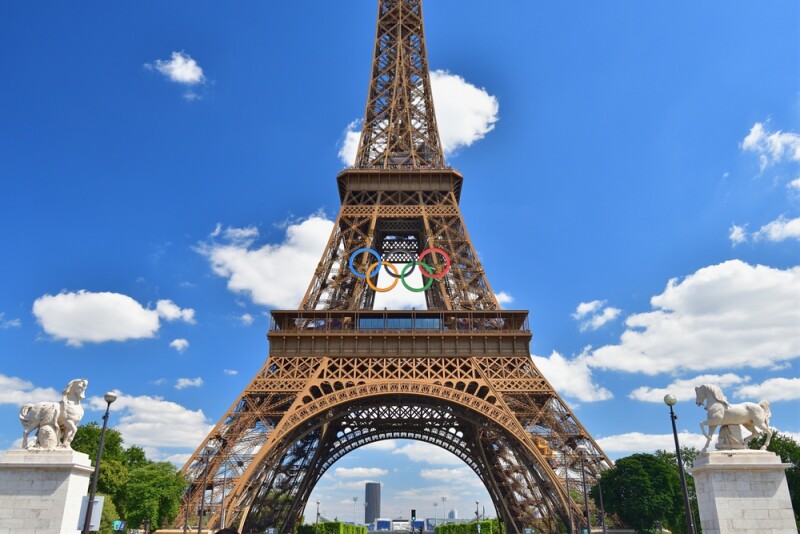 The Eiffel Tower adorned with the Olympic symbol, as seen from the pedestrian zone on the Iéna Bridge.