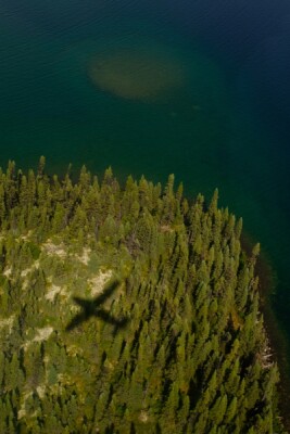 Shadow of Grand Caravan flying over Labrador, Canada landscape.