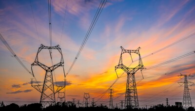 High voltage power tower and sky clouds at dusk