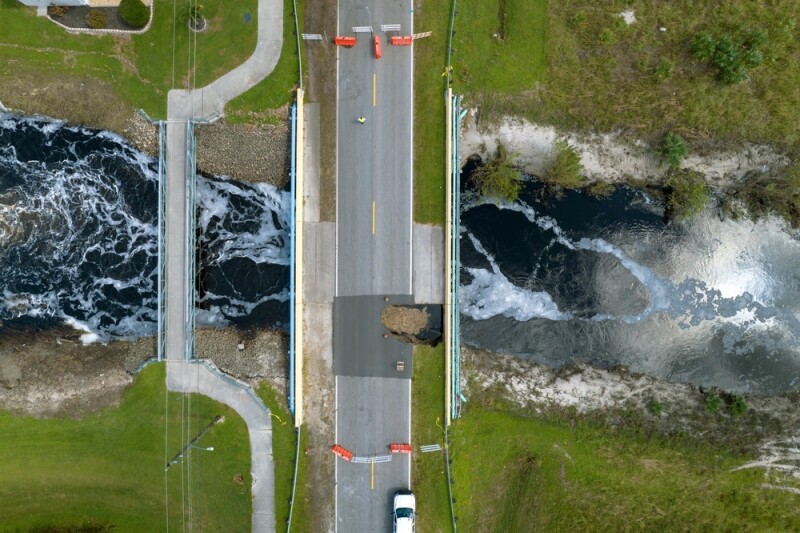 Repair of destroyed bridge after hurricane flooding water washed away asphalt in Florida.