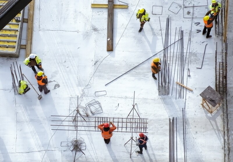 Workers in orange and yellow robes doing their job at the construction site.