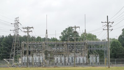 A complex array of transformers, switches, and circuit breakers, encased in a secure facility, buzzing with energy, modulating and distributing electricity across the grid.