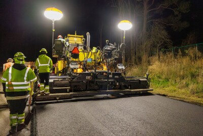 A road paving machine being operated at night