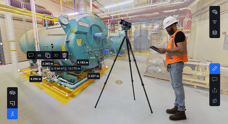 Worker standing next to FARO Blink on a tripod within a facility