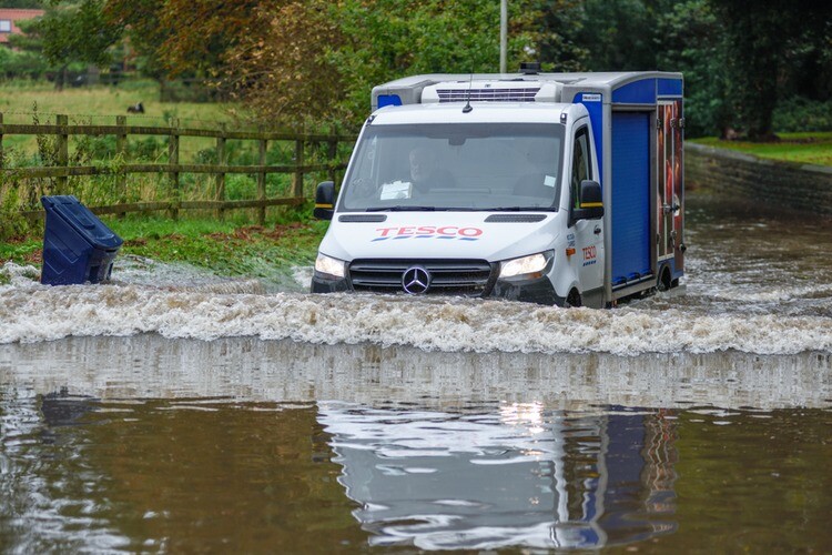 Van driving through a flooded road in the UK.