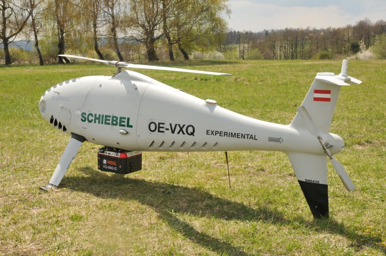 Schiebel UAV integrated with sensor from RIEGL parked on a field.