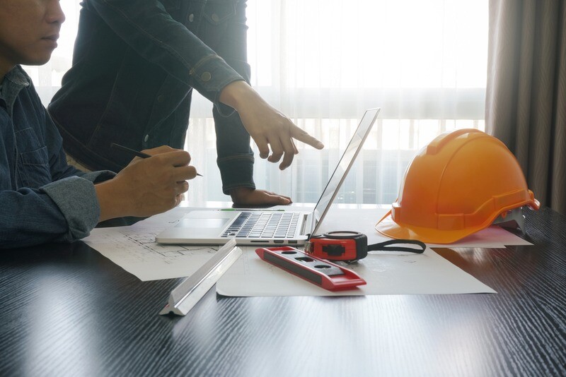 architects and engineer discussing on working table with blueprint and construction tools.