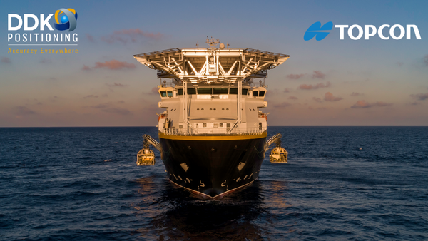 Ship in water with logos for DDK Positioning and Topcon on either side of it.