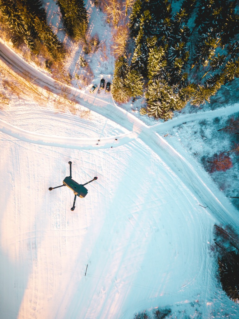 Drone flying over snowy landscape.
