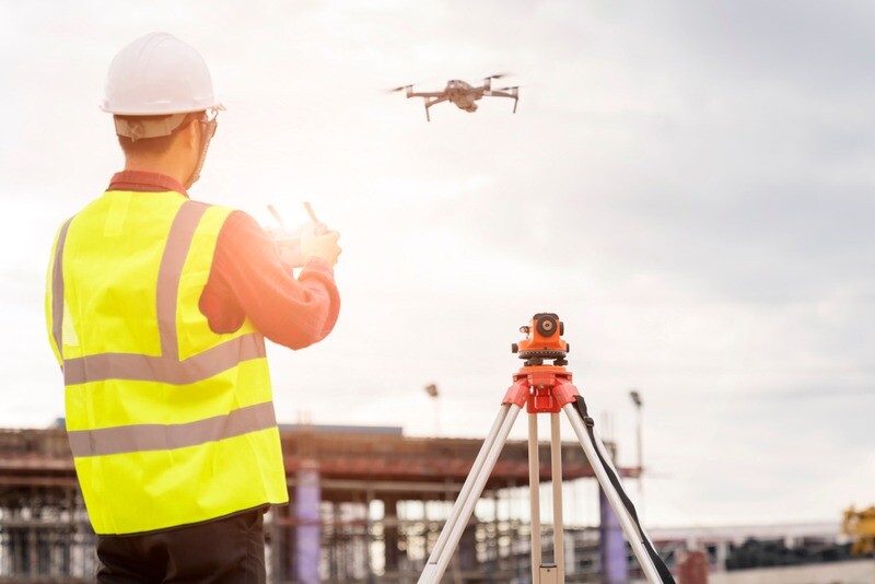Engineer working at construction Site with Drone over construction site.