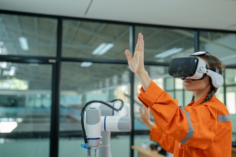 Woman in factory wearing VR headset.