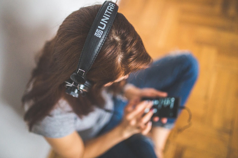 Woman with headphones and mobile device