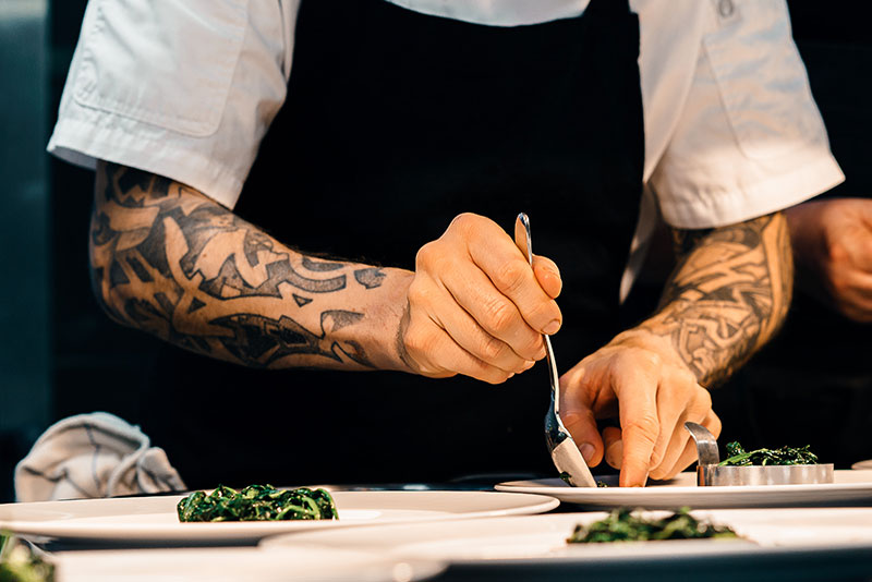 A chef plating dishes with food.