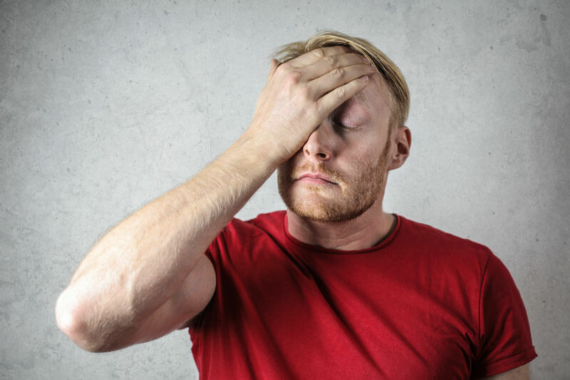 Man with hand on forehead ache