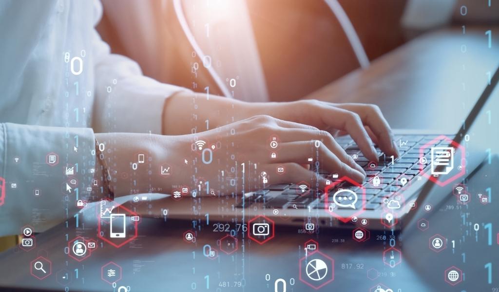 Person working at laptop with abstract imagery overlaid depicting icons that represent: chat, chart, phone, message, globe, signal, and email
