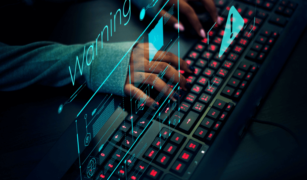 Keyboard in front of computer with holographic warnings of fraud