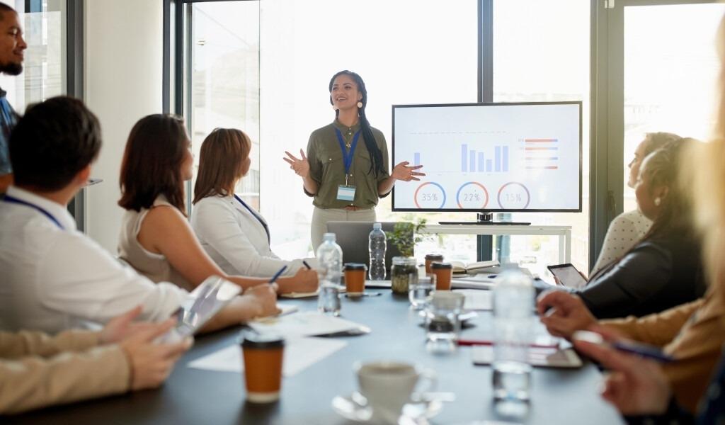 Woman giving a presentation to her table of coworkers