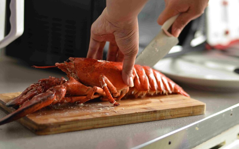 Cooked lobster on cutting board with knife