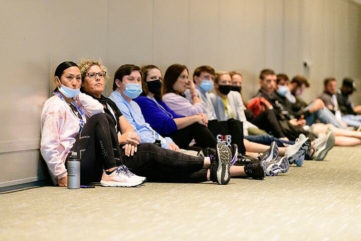 People sitting on floor for keynote presentation