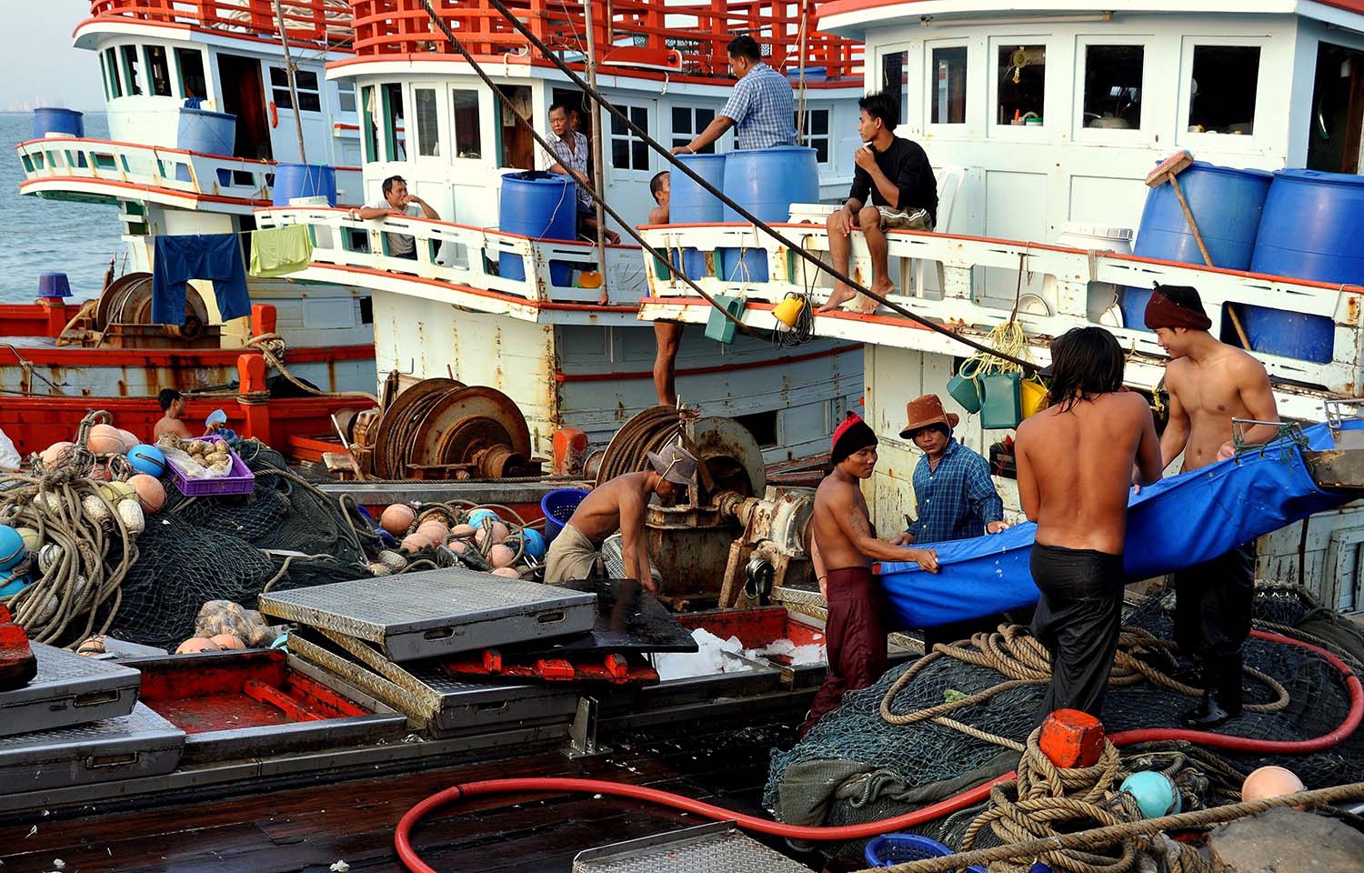 Workers load ice onto fishing vessels in Thailand