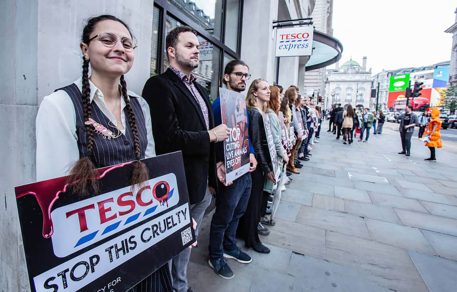 Mercy for Animals protestors outside of a Tesco location with signs decrying cruel animal-slaughter methods