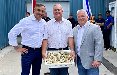 Canada Department of Fisheries and Oceans staff posing with a case of whelks.