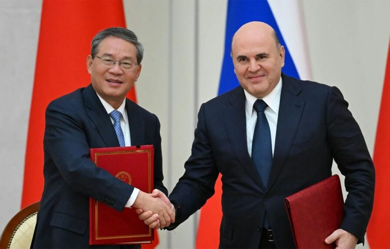 Chinese Premier Li Qiang and Russian Prime Minister Mikhail Mishustin shaking hands