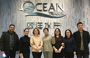 Ocean Treasure's staff posing in front of the company's logo.