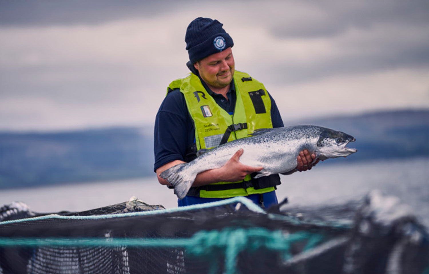 A Bakkafrost farmer holding one of the company's farmed salmon.