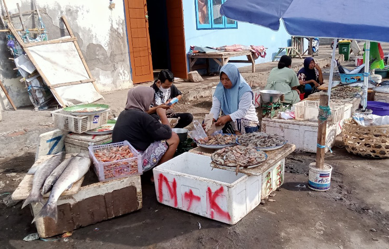 A woman selling shrimp at an outdoor market in Indonesia