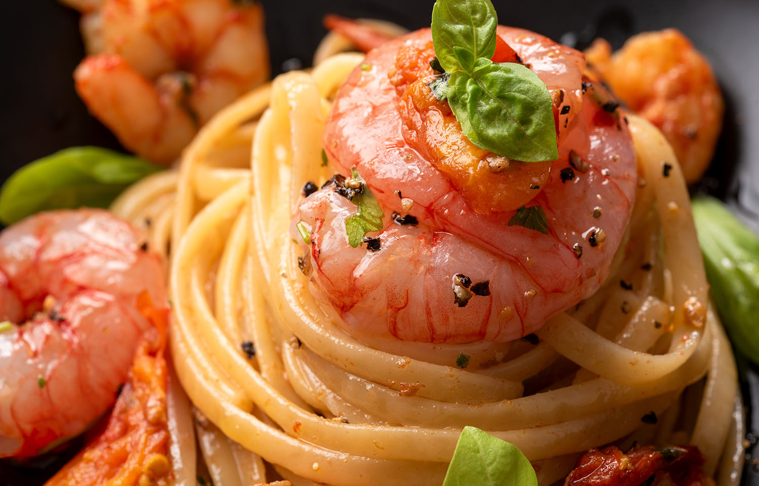 A cooked shrimp on a pile of linguini