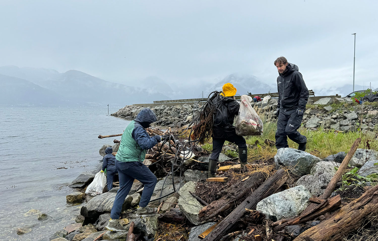 A group of volunteers cleaning up trash in a Norwegian fjord