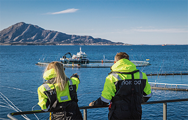 Two Norcod employees on board one of the company's net pens in the ocean.