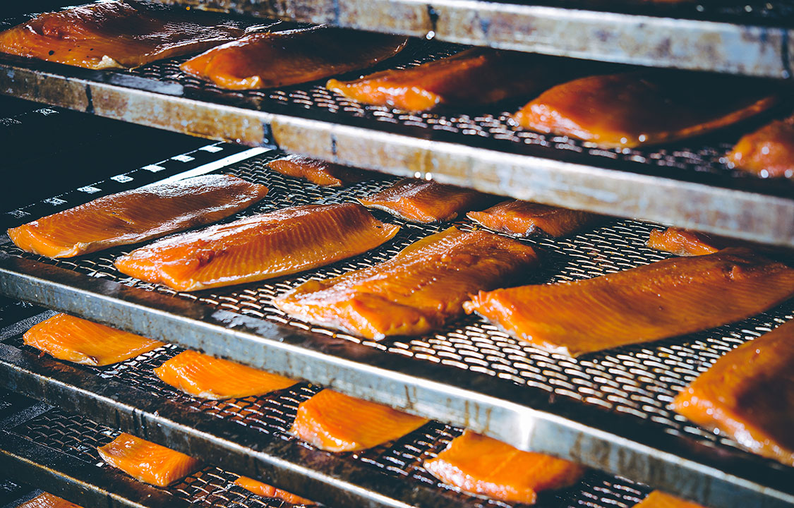 A rack of smoked salmon in a seafood processing facility