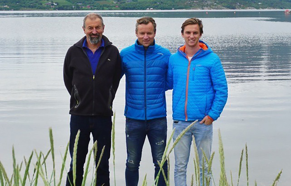 Three generations of Andreassens pose by a fjord in Norway