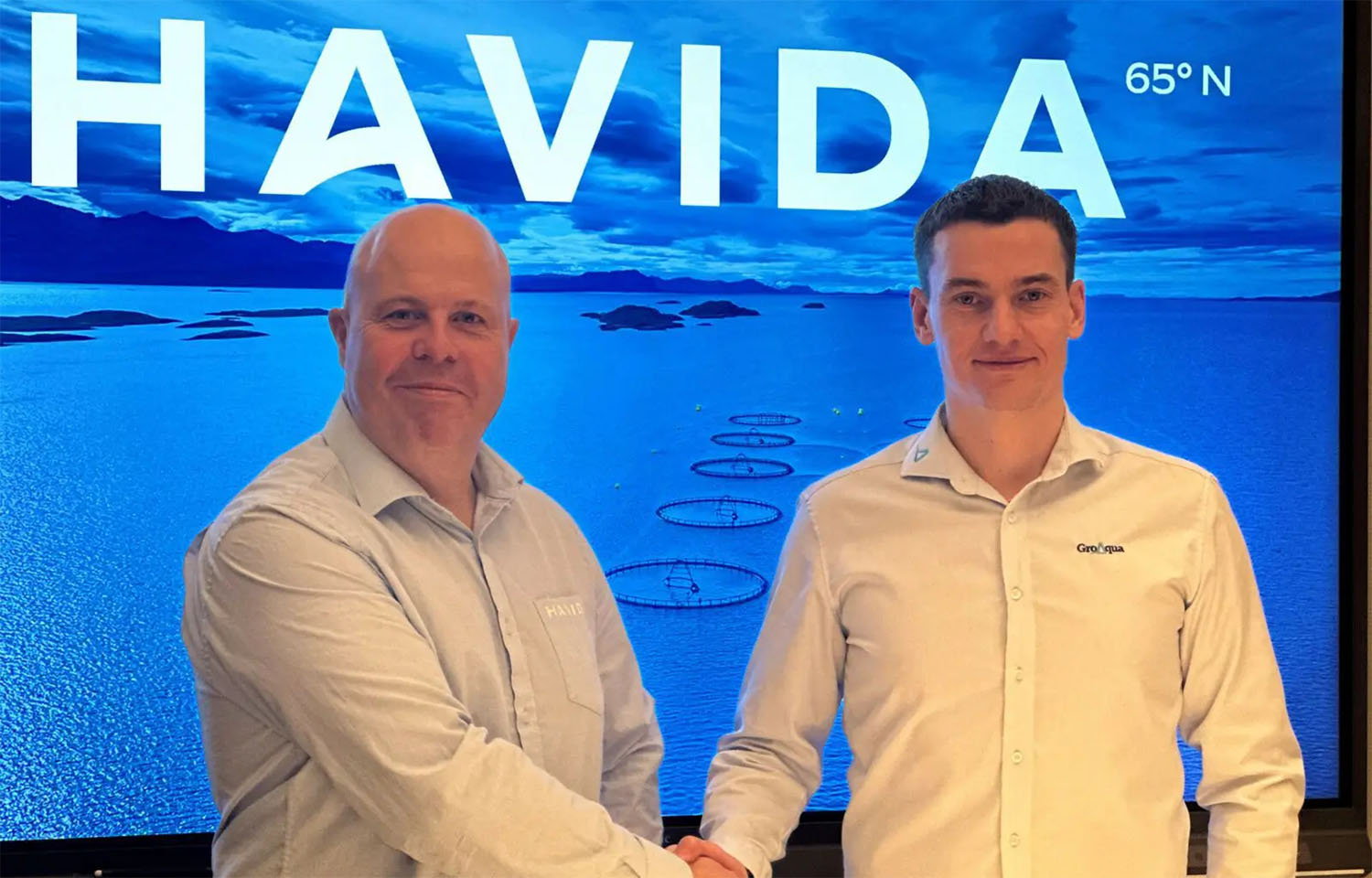 The leadership of Havida and GroAqua shake hands on a merger of the two companies.