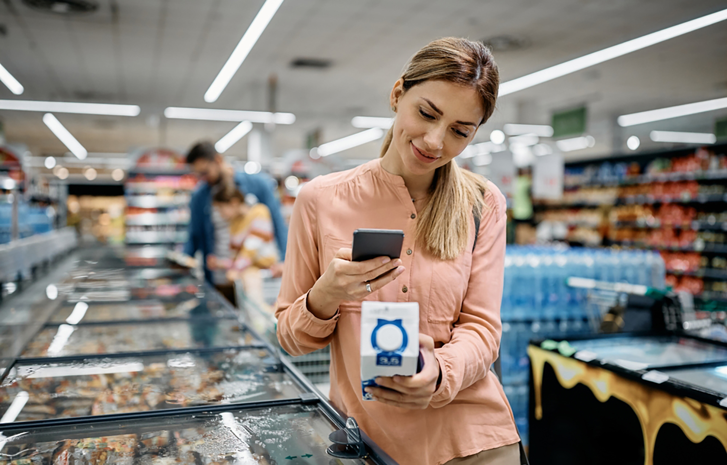 A woman scanning a QR code at a grocery store