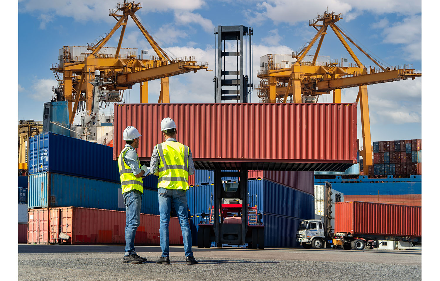 Two people in front of a shipping container at a port