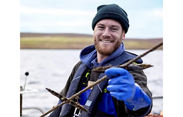 A Scottish fisherman holds up a freshly-caught langoustine