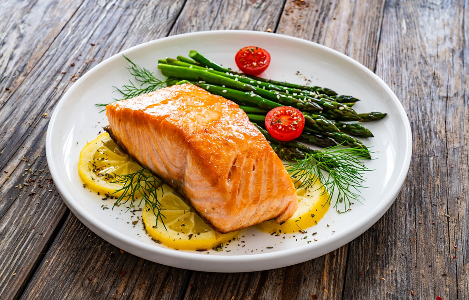 A plate with salmon and asparagus on it