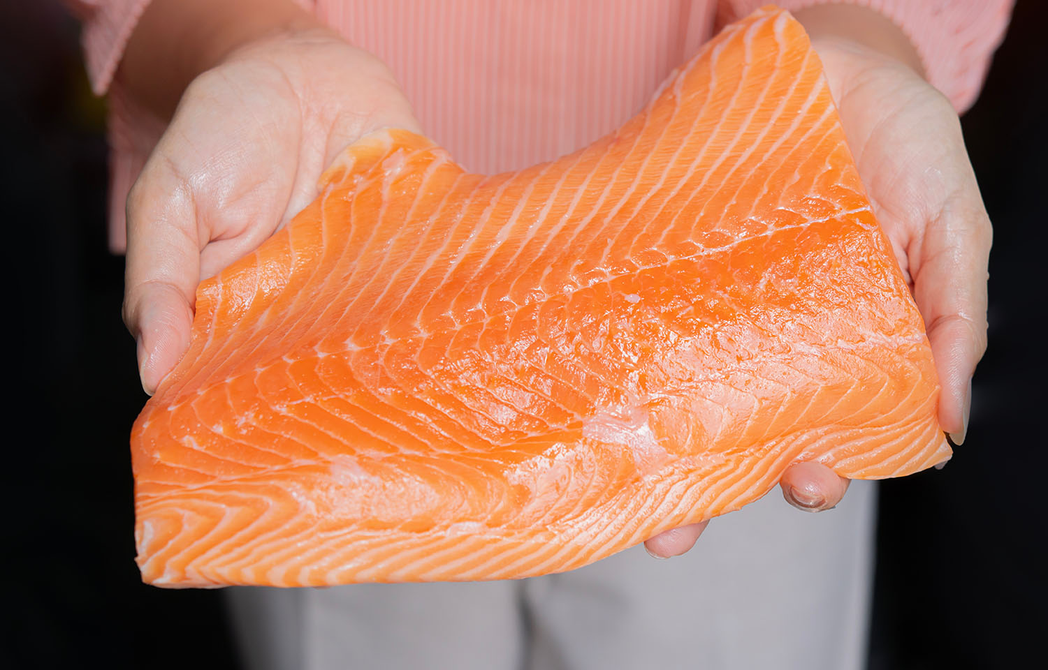 A person holding an Atlantic salmon fillet