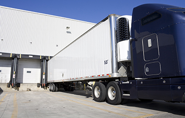 A transport truck at a warehouse dock.
