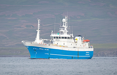 A fishing vessel heading out to sea.