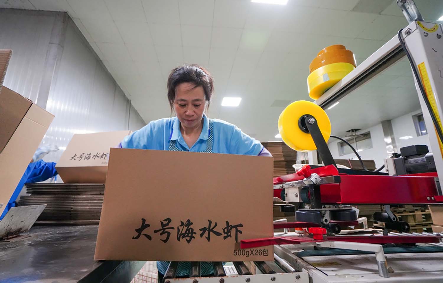 A woman packing a box full of prawns