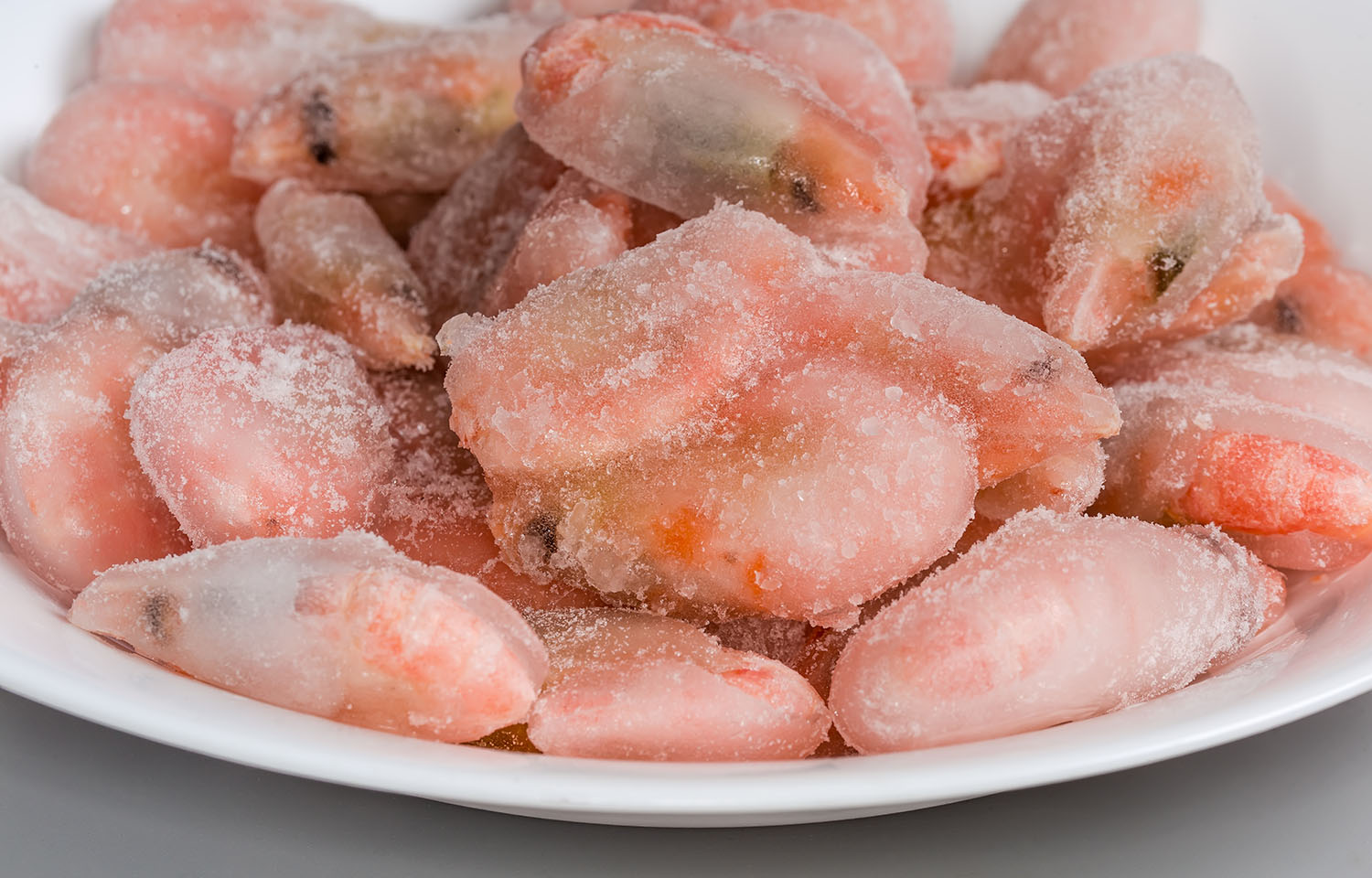 A bowl of shrimp covered in a thick layer of ice