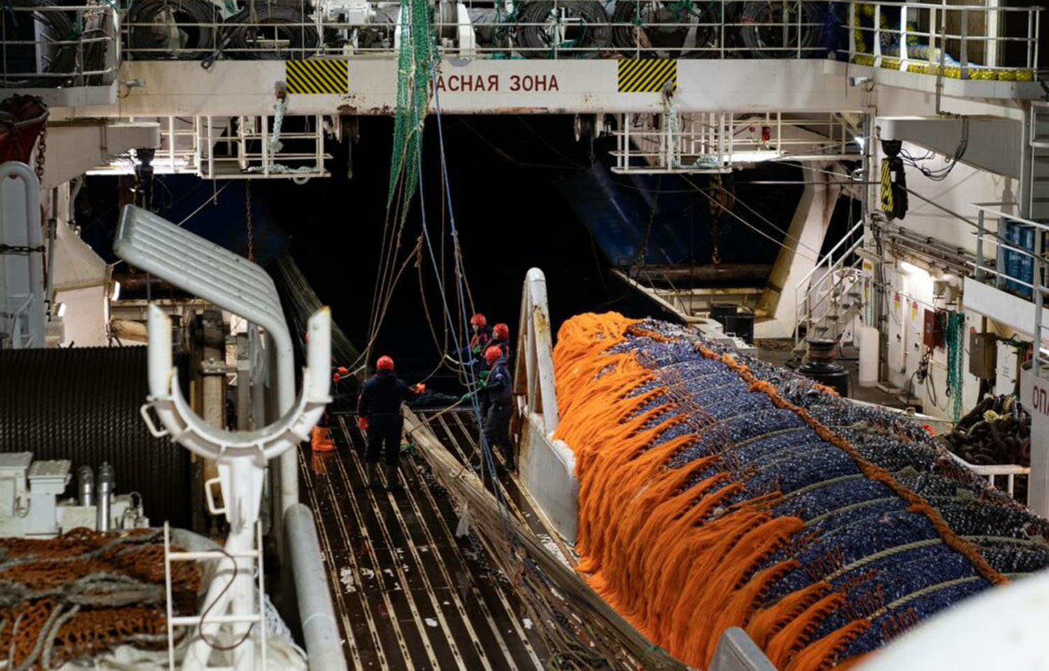 Workers on a Russian fishing vessel pull in a net