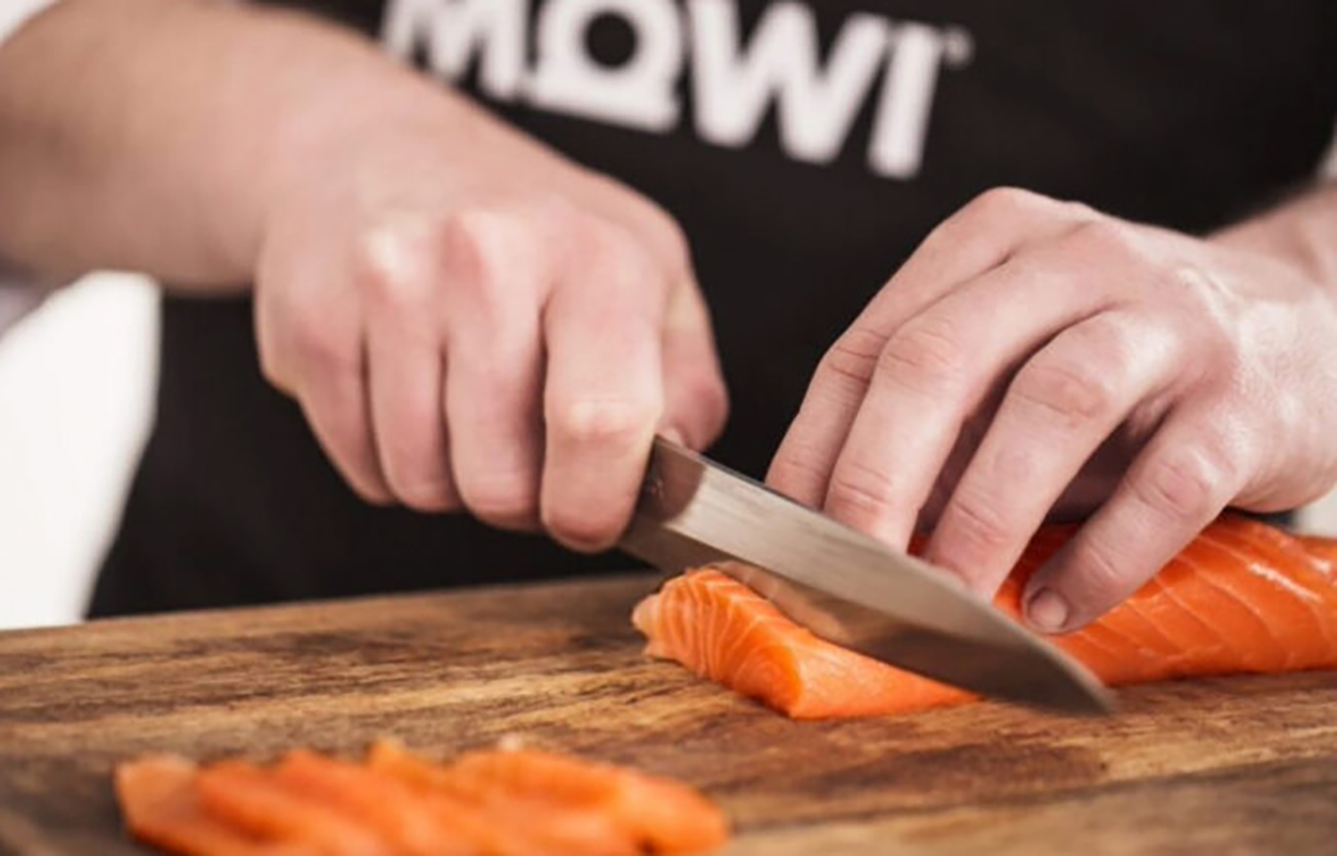 A chef cutting a Mowi salmon fillet