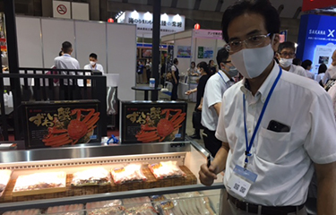 Satoru Kasei of Tsukiji Kansho next to packages of crab his company produces.