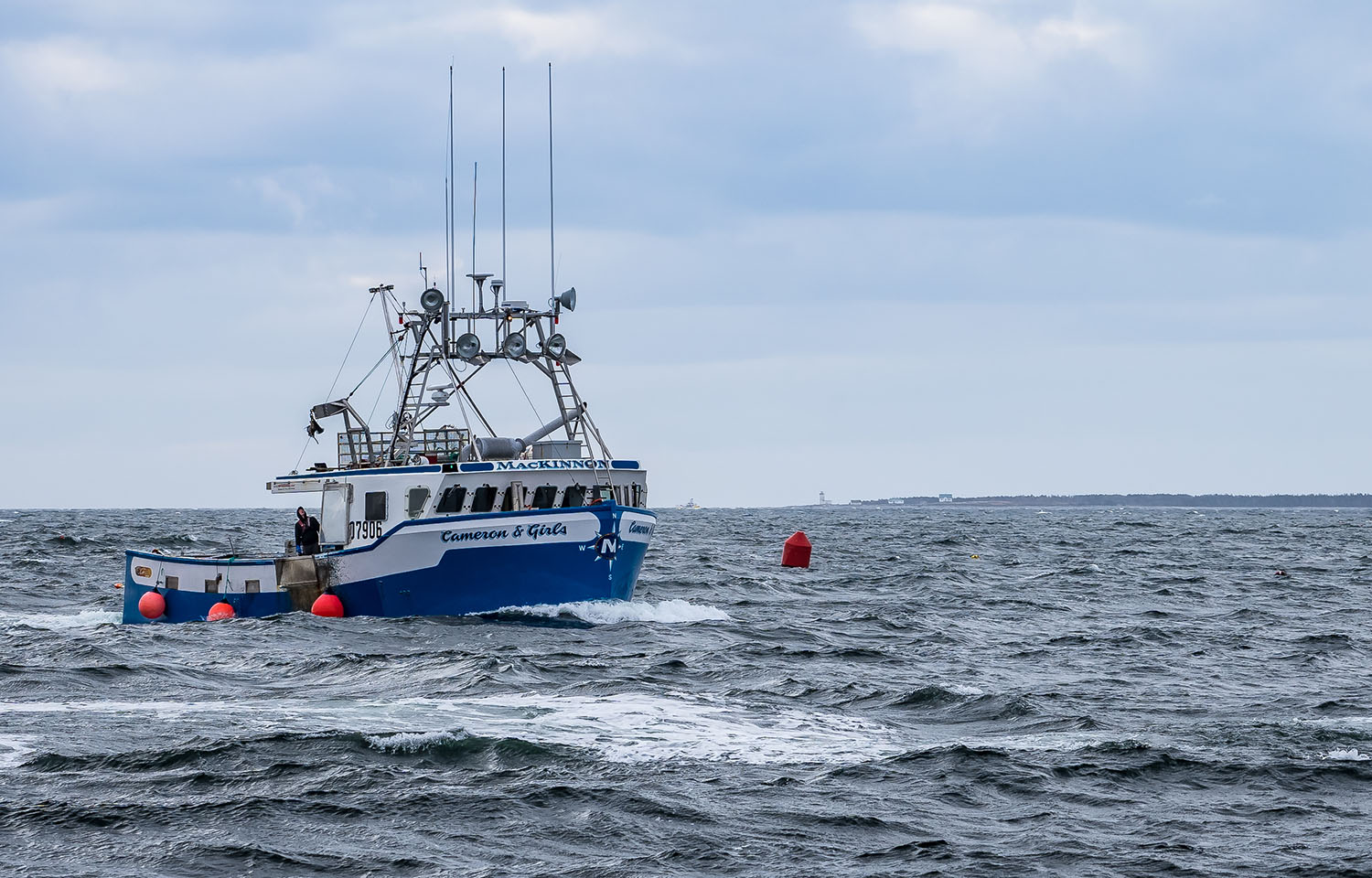 A lobster boat sailing in choppy waters off the coast of Nova Scotia, Canada