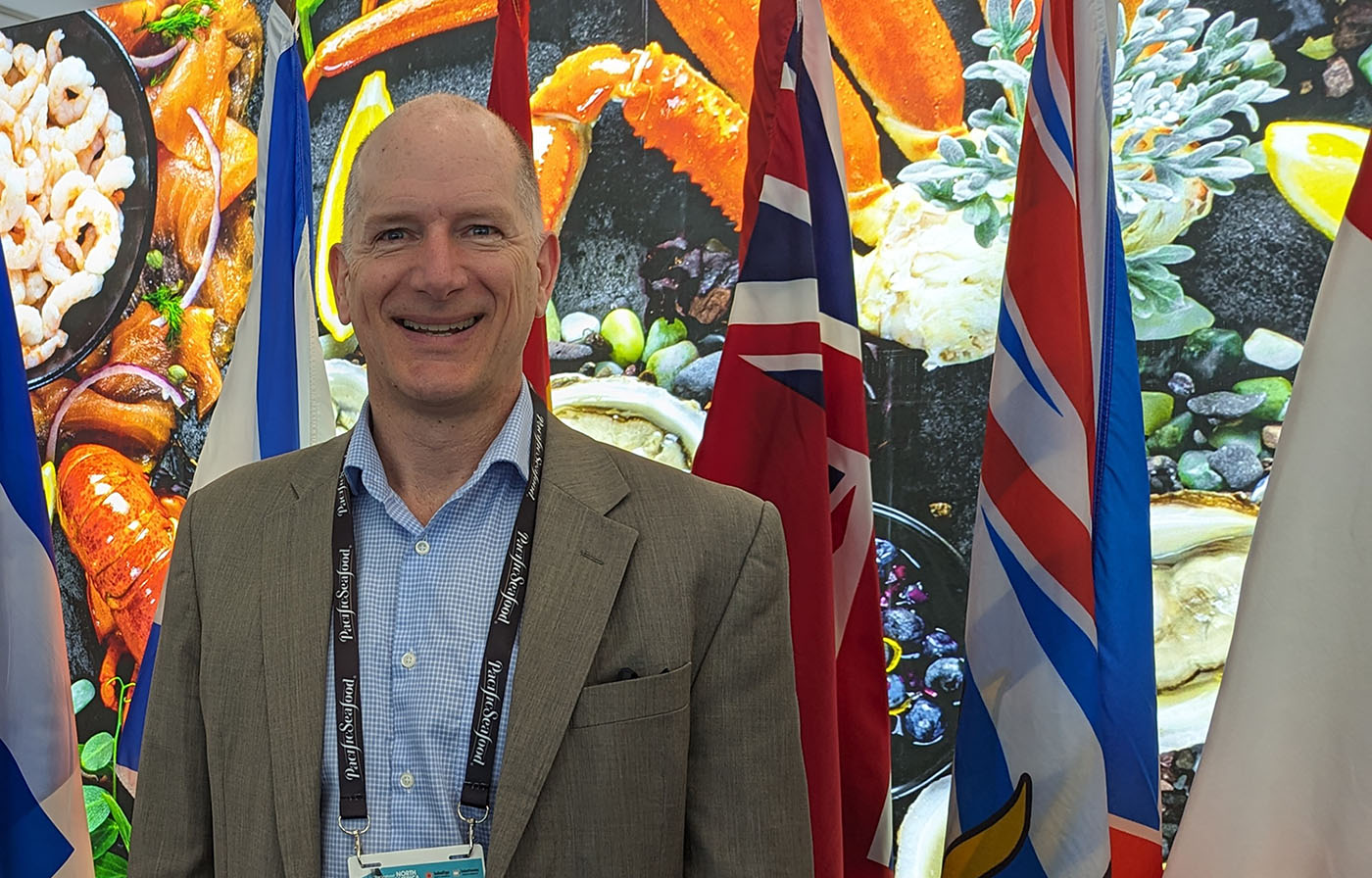 IFCA Chair Paul Lansbergen in front of a background of flags
